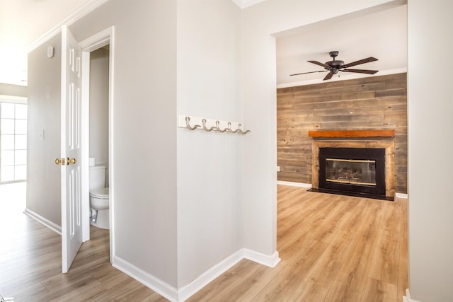 hall with crown molding, baseboards, and wood finished floors