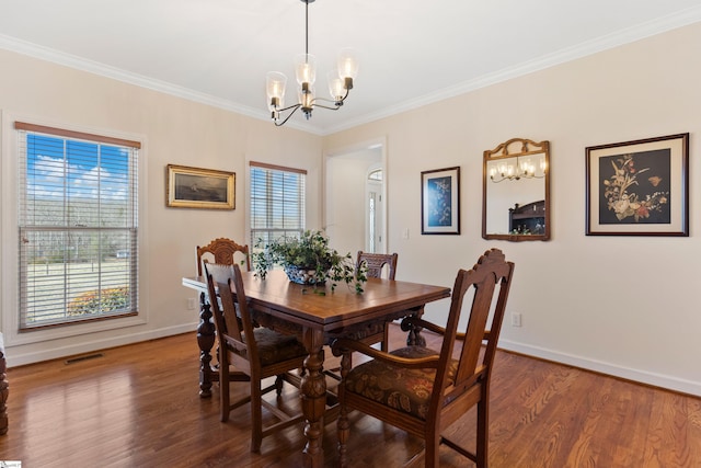 dining area with an inviting chandelier, baseboards, wood finished floors, and ornamental molding