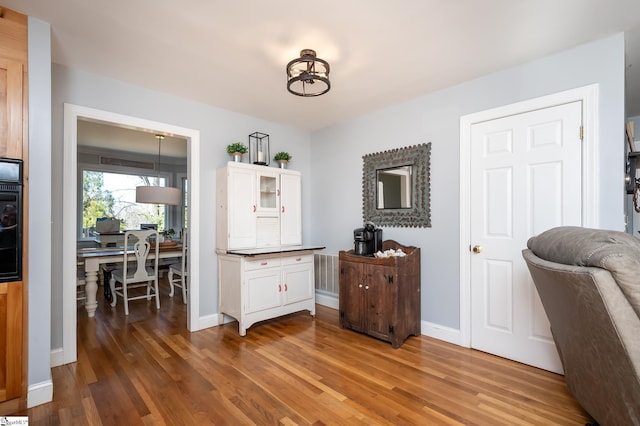 interior space with visible vents, baseboards, and wood finished floors