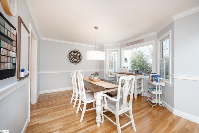 dining room featuring ornamental molding, wood finished floors, and baseboards