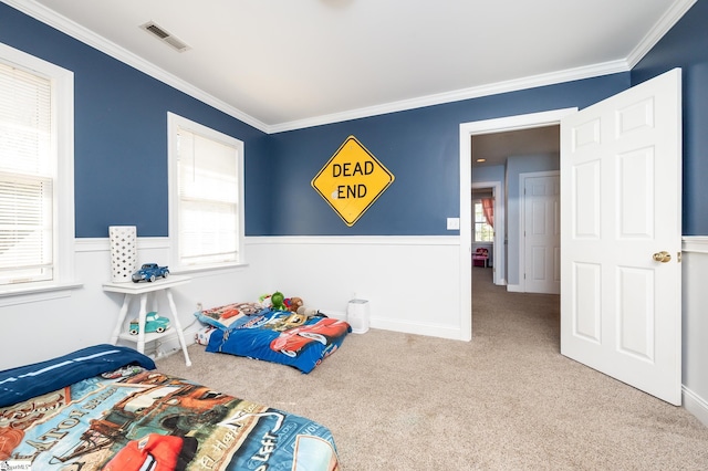 bedroom featuring carpet, wainscoting, visible vents, and multiple windows