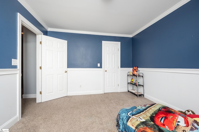 bedroom featuring carpet floors, wainscoting, and crown molding