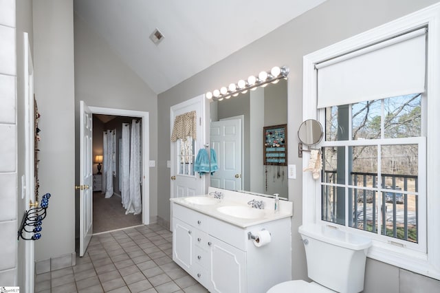 bathroom with lofted ceiling, a sink, visible vents, and tile patterned floors