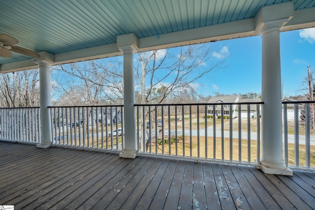 wooden deck with a residential view and a ceiling fan