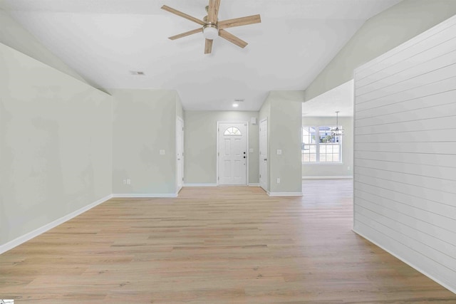 interior space featuring lofted ceiling, baseboards, light wood finished floors, and ceiling fan with notable chandelier