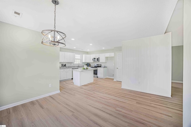 kitchen with light wood finished floors, light countertops, visible vents, appliances with stainless steel finishes, and white cabinetry