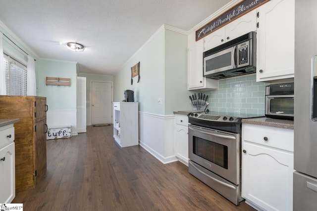 kitchen featuring a textured ceiling, white cabinetry, appliances with stainless steel finishes, dark wood-style floors, and crown molding