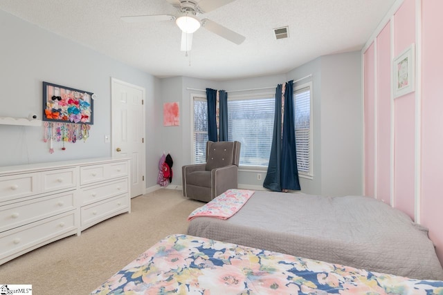 bedroom with light carpet, baseboards, visible vents, and a textured ceiling