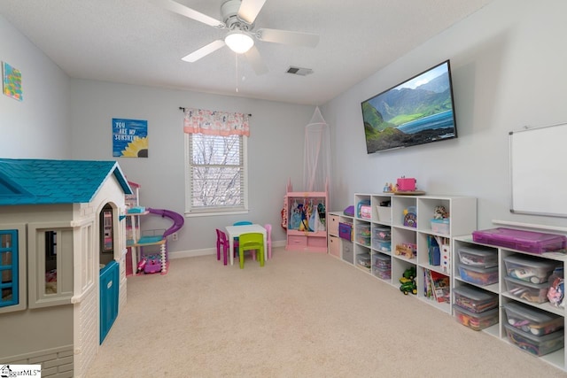 playroom featuring baseboards, visible vents, ceiling fan, a textured ceiling, and carpet floors