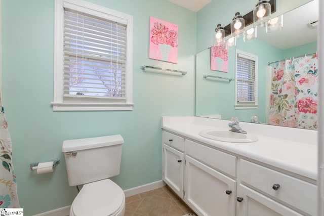 bathroom with toilet, vanity, baseboards, and tile patterned floors