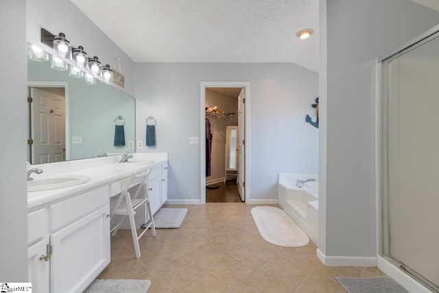 full bathroom with a sink, a shower stall, a textured ceiling, and a bath