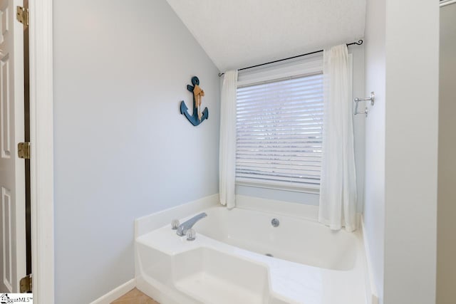 full bathroom with a garden tub and a textured ceiling