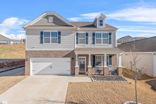 craftsman-style home featuring driveway, roof with shingles, an attached garage, a porch, and brick siding