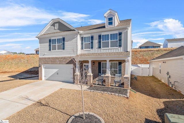 view of front of home with covered porch, board and batten siding, a gate, fence, and driveway