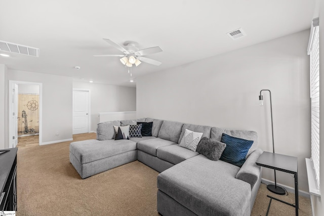 carpeted living area featuring ceiling fan, visible vents, and baseboards