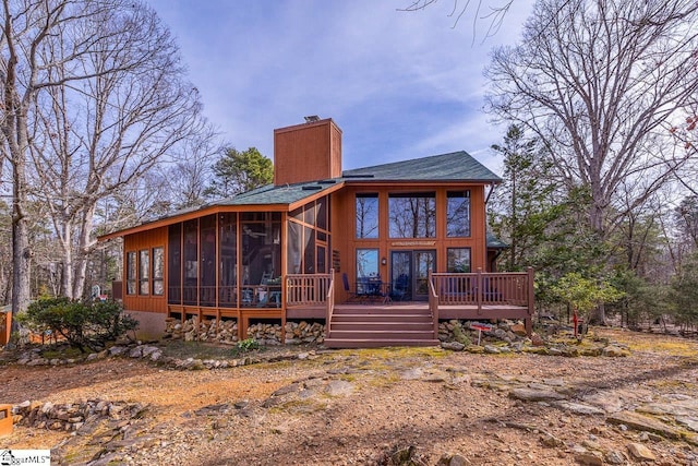 back of house with a chimney and a sunroom