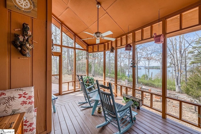 sunroom with vaulted ceiling, a water view, and a ceiling fan