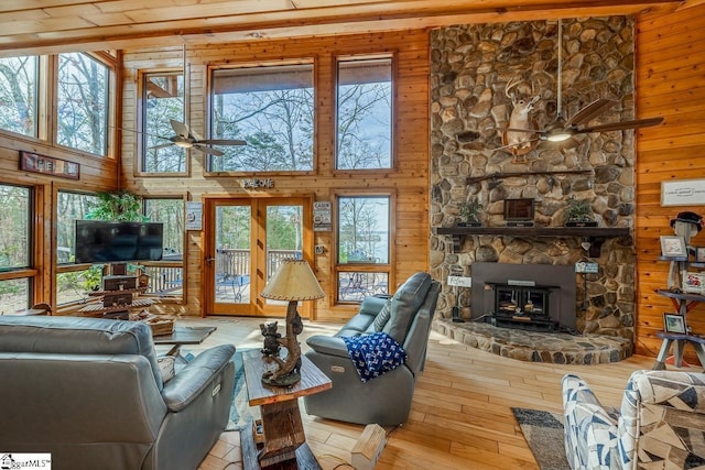 living area with plenty of natural light, ceiling fan, and wooden walls