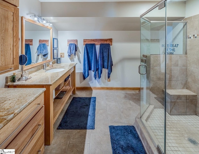 bathroom with baseboards, tile patterned flooring, vanity, and a shower stall