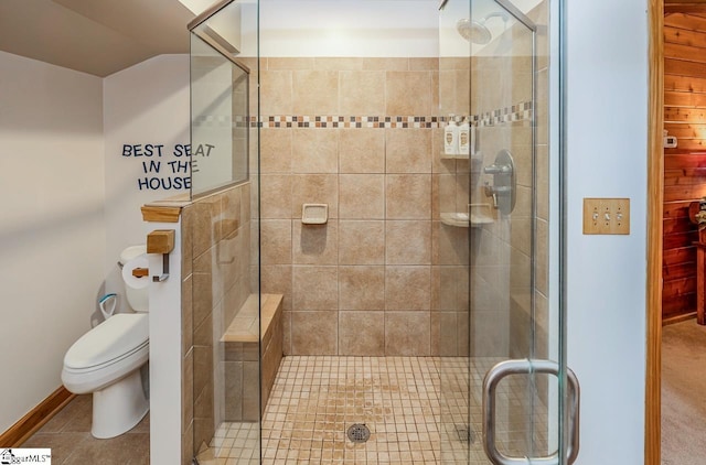 bathroom featuring tile patterned flooring, a shower stall, and toilet