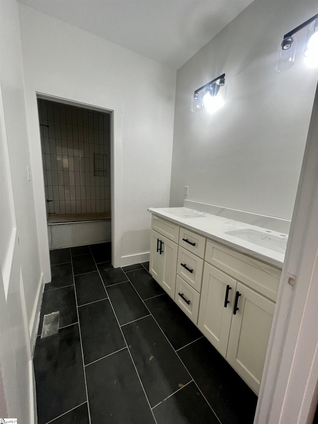 full bathroom featuring a sink, double vanity, tile patterned flooring, and baseboards