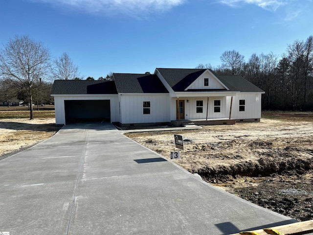 modern farmhouse style home featuring an attached garage, covered porch, a shingled roof, concrete driveway, and crawl space