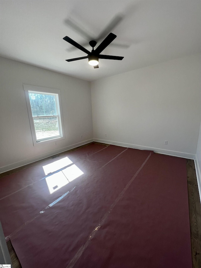 unfurnished room with ceiling fan and baseboards