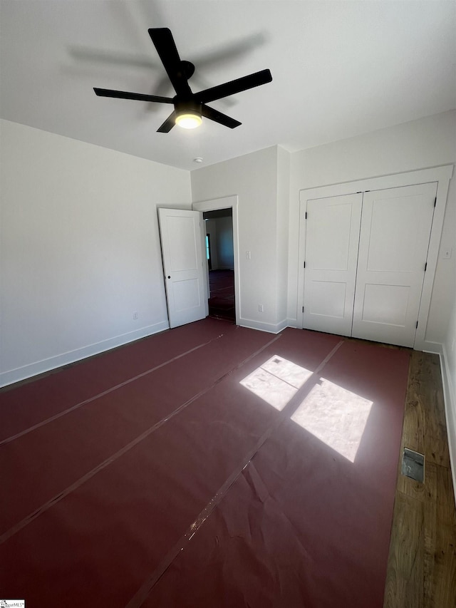 unfurnished bedroom featuring a ceiling fan, a closet, and baseboards