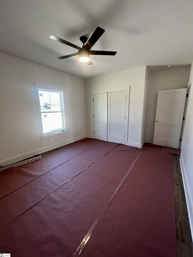 unfurnished bedroom with a closet, ceiling fan, and baseboards