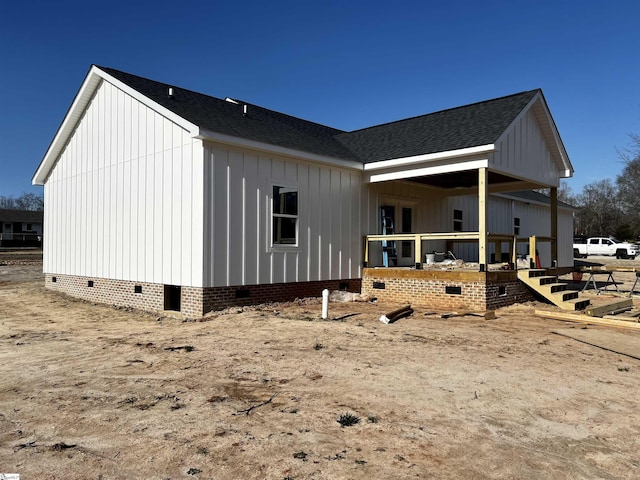 view of property exterior featuring roof with shingles, crawl space, and board and batten siding