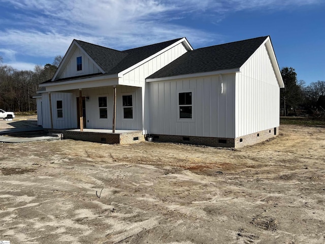 view of front of house featuring covered porch, a shingled roof, crawl space, and board and batten siding