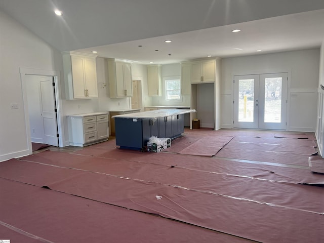 kitchen with french doors, recessed lighting, white cabinets, a kitchen island, and baseboards