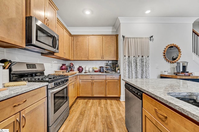 kitchen with light wood finished floors, light stone counters, ornamental molding, stainless steel appliances, and backsplash