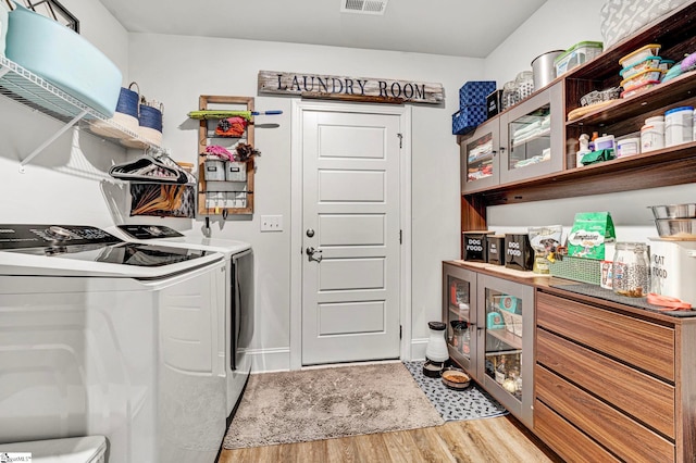 laundry area featuring light wood-type flooring, laundry area, visible vents, and independent washer and dryer