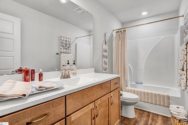 full bath with visible vents, toilet, wood finished floors, shower / bath combination with curtain, and vanity