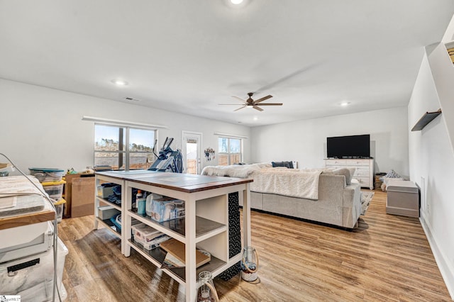 living room featuring light wood-type flooring, ceiling fan, baseboards, and recessed lighting