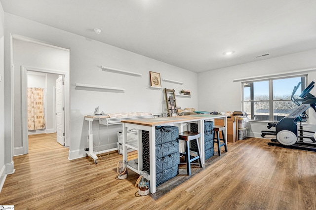 kitchen with baseboards, visible vents, and wood finished floors