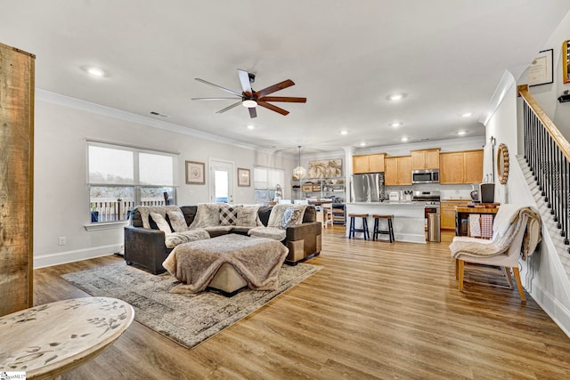 living area featuring light wood finished floors, visible vents, ceiling fan, crown molding, and recessed lighting