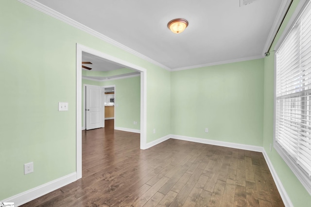 spare room with crown molding, dark wood finished floors, and baseboards