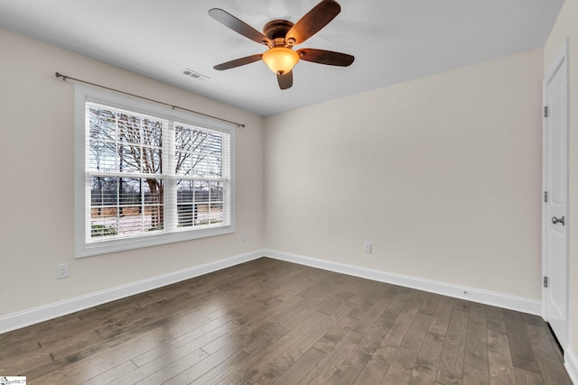 spare room with ceiling fan, baseboards, visible vents, and dark wood finished floors