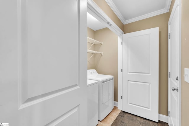 laundry area with laundry area, baseboards, crown molding, and washing machine and clothes dryer