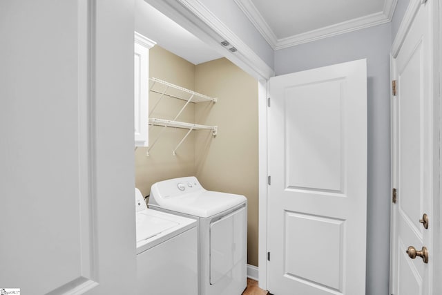 laundry area featuring laundry area, crown molding, and washing machine and clothes dryer