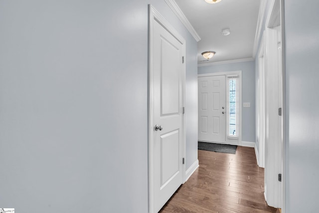 entryway with ornamental molding, wood finished floors, and baseboards