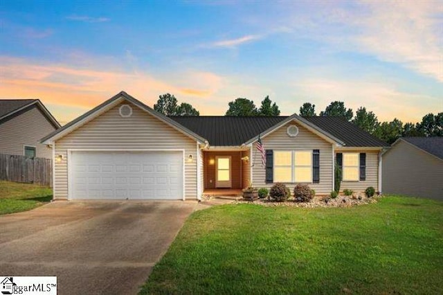 ranch-style house with a front yard, metal roof, fence, a garage, and driveway