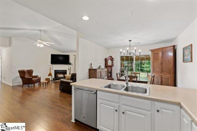 kitchen with dishwasher, a fireplace, a sink, and white cabinets