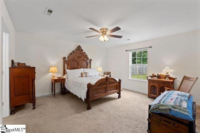 bedroom featuring baseboards, a ceiling fan, visible vents, and light colored carpet