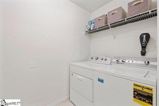 laundry area with laundry area, washing machine and clothes dryer, and baseboards