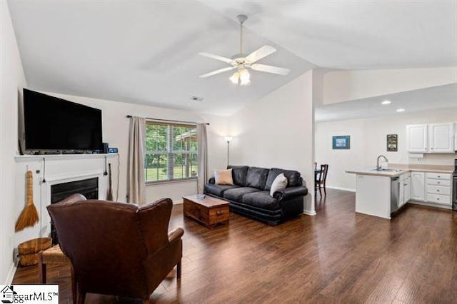 living room with ceiling fan, lofted ceiling, a fireplace, baseboards, and dark wood-style floors