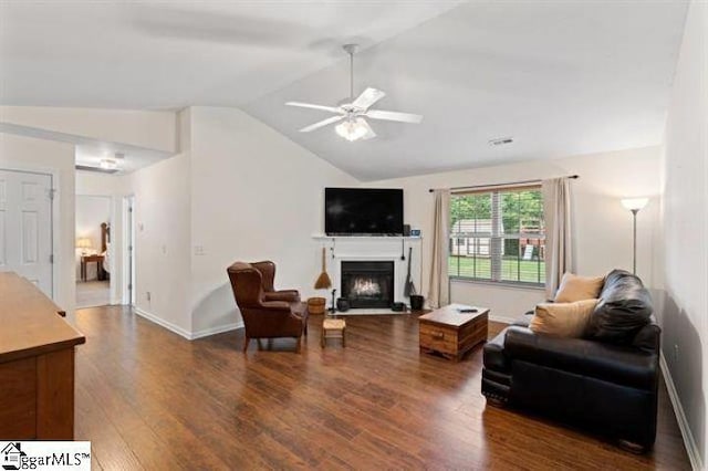 living room with a fireplace, lofted ceiling, a ceiling fan, wood finished floors, and baseboards