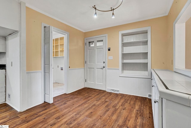 entryway featuring wainscoting, wood finished floors, visible vents, and crown molding